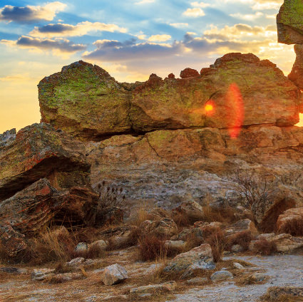 Early sunrays burst through the rocks: At RIVO International we use each day to stimulate success.