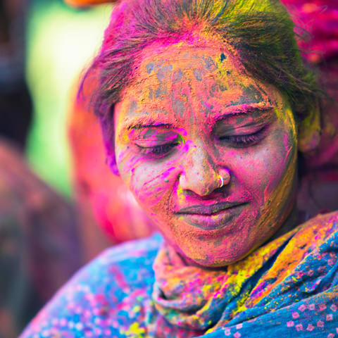 An Indian woman is covered in ceremonial paint: At RIVO International we celebrate social responsibility.>